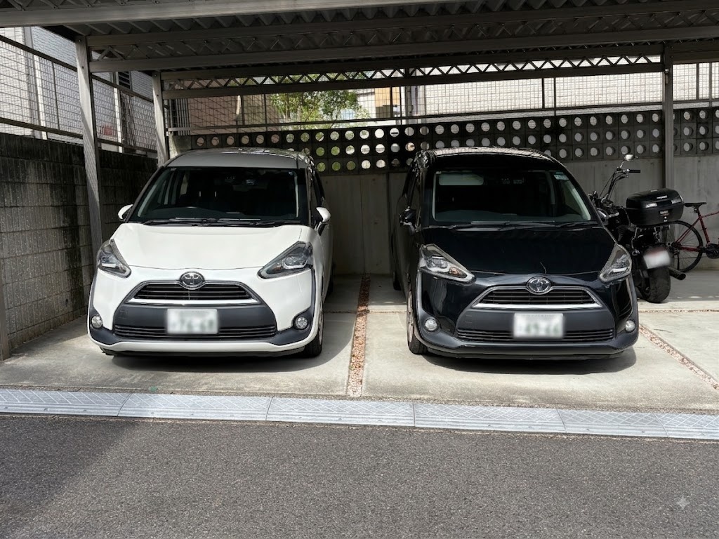 カーポートに並んで駐車された白と黒のシエンタを正面から撮影